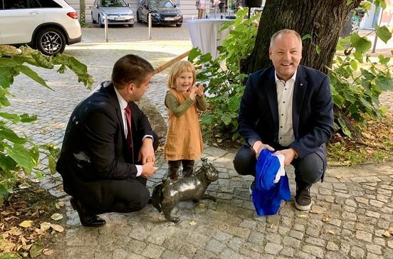 Oberbürgermeister Steffen Scheller (l.) und Thomas Krüger (Geschäftsführer der STG) enthüllen gemeinsam mit Clara, Tochter der Waldmops-Künstlerin.