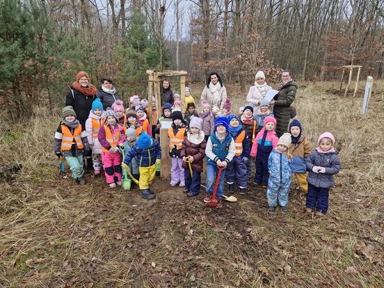 Eine Kindergartengruppe vor einem gepflanzten Baum.