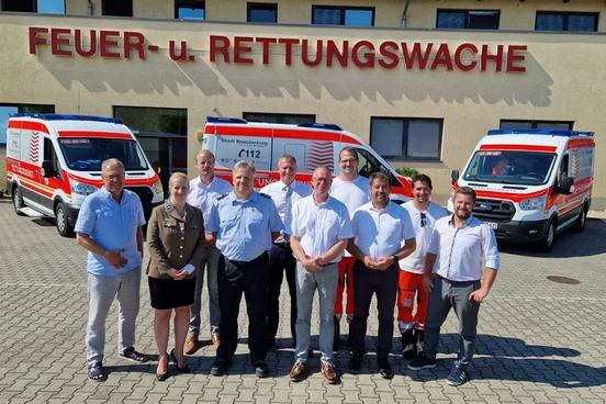 OB Steffen Scheller (3. von re.) und der Beigeordnete Thomas Barz (6. von re.) übergaben die Krankenwagen an das Rettungsteam