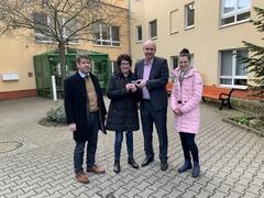 Vier Personen vor Haus