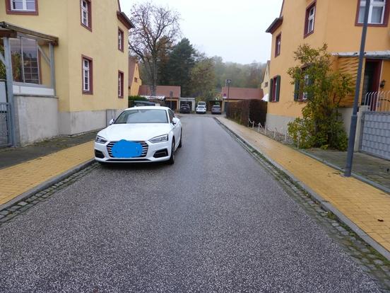 Das Foto zeigt ein Fahrzeug, das in der Turmstraße am Fahrbahnrand parkt. Die Straße ist sehr schmal.