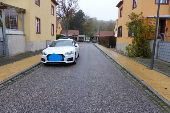 Das Foto zeigt ein Fahrzeug, das in der Turmstraße am Fahrbahnrand parkt. Die Straße ist sehr schmal.