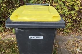 schwarze Tonne mit gelben Deckel.