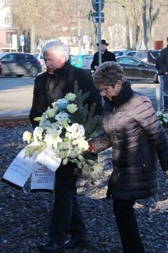 Die Oberbürgermeisterin und der SVV-Vorsitzende tragen gemeinsam einen Gedenkkranz