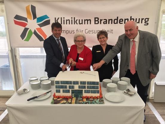 Oberbürgermeister Steffen Scheller, Geschäftsführerin Gabriele Wolter, Dr. Dietlind Tiemann (MdB) und Georg Riethmüller (Bauverantwortlicher) schneiden die Torte an.