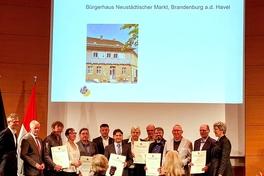 Eine Menschengruppe erhält eine Auszeichnung.