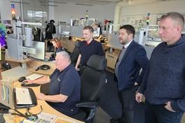 Beigeordneter Thomas Barz, Steffen Scheller und Feuwehrleiter Sebastian Kalka schauen in der Leitstelle Bernd Karge über die Schulter