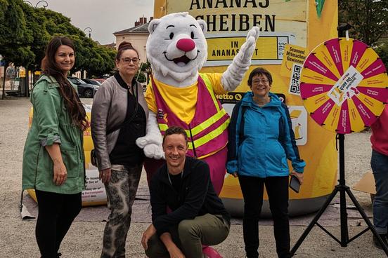 Die Mitarbeiterinnen und Mitarbeiter vom Amt für Abfallwirtschaft, Bodenschutz und Grünflächen vor der großen Ananas und dem Trenn-Bären