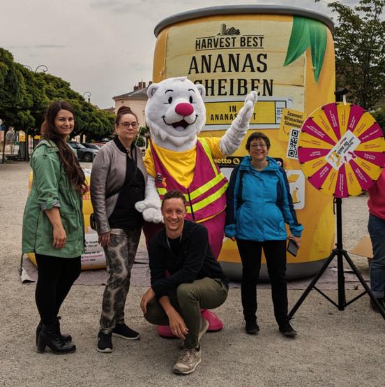 Die Mitarbeiterinnen und Mitarbeiter vom Amt für Abfallwirtschaft, Bodenschutz und Grünflächen vor der großen Ananas und dem Trenn-Bären