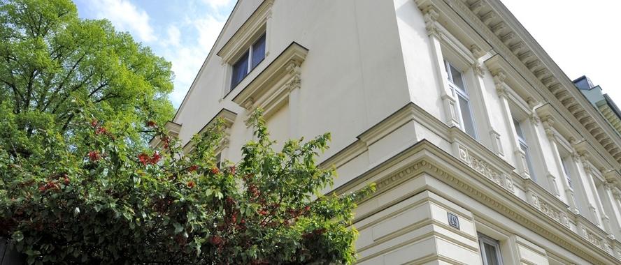 Gartenidyll Historisches Wohnhaus mit renovierter Fassade und einem großen Baum an der Seite