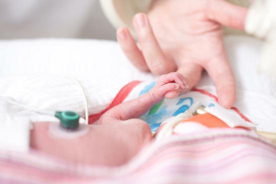 Ein Frühgeborenes greift die Hand eines Erwachsenen. Quelle: Universitätsklinikum Brandenburg an der Havel