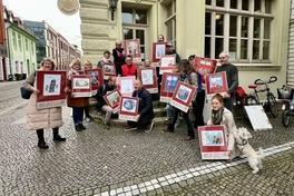 viele Menschen stehen in einer Gruppe und halten Plakate hoch.