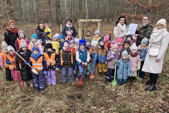 Kindergartengruppe pflanzt Baum im Bürgerwald