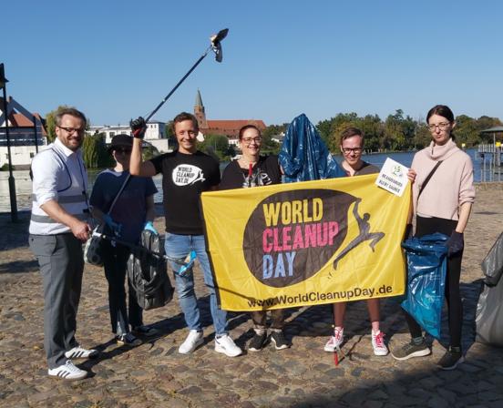 Bürgermeister Michael Müler und Amtsleiterin Kirstin Ohme präsentieren mit Mitarbeitern das Banner der Aktion.