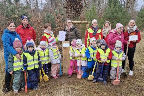 Eine Kindergartengruppe vor einem Baum.