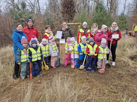 Eine Kindergartengruppe vor einem Baum.