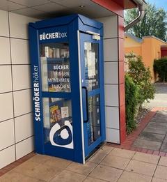 eine blaue Büchertauschbox in Form einer umgestalteten Telefonzelle