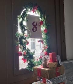 Zahl Nummer 8 am Fenster, mit Tannenzweige umrahmt,