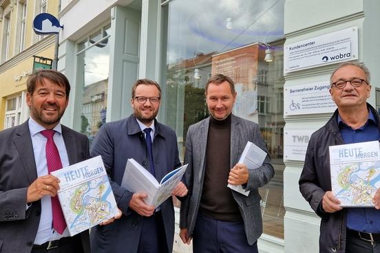 Buchpräsentation vor dem wobra-Kundencenter mit Oberbürgermeister Seffen Scheller, Bürgermeister Michael Müller, wobra-Geschäftsführer Stephan Falk.