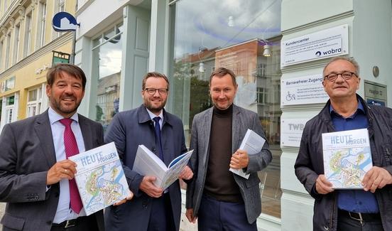 Buchpräsentation vor dem wobra-Kundencenter mit Oberbürgermeister Seffen Scheller, Bürgermeister Michael Müller, wobra-Geschäftsführer Stephan Falk.