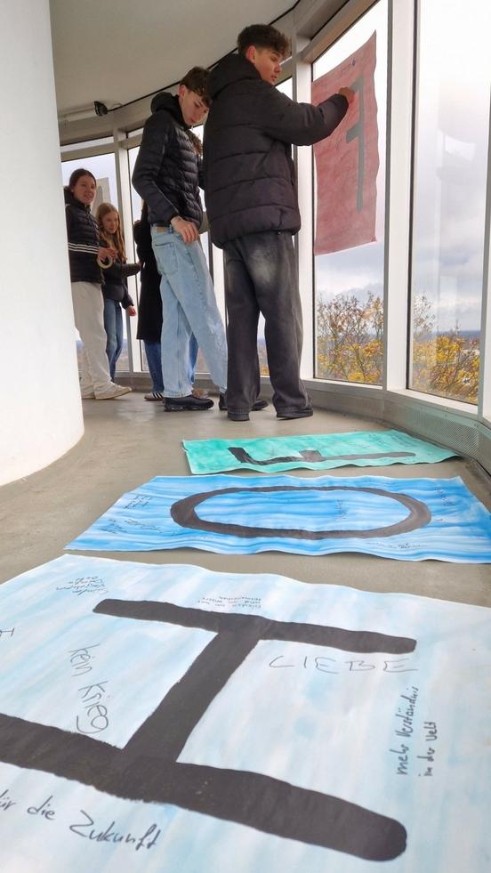 Schülerinnen und Schüler des Religionskurses der 10. Klassen am Dom-Schulcampus befestigten ihre friedensstiftenden Botschaften an der Friedenswarte.