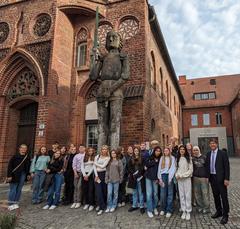Gruppenbild Schulklasse vor Steinstatue