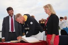 OB Scheller und Staatssekretärin Zinke sehen zu wie sich Olympiasieger Max Rendschmidt ins Goldene Buch der Stadt einträgt