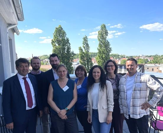 Mitglieder des Netzwerk Zukunft Pflege stehen mit dem Oberbürgermeister auf einer Terasse.