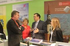 Dr. Dietlind Tiemann in ihrer Rolle als Vorstandsmitglied und Vorsitzende der Regionalgruppe Süd-West der AG Städte mit historischen Stadtkernen im Gespräch mit den Ministern für Wirtschaft, Ralf Christoffers, und für Infrastruktur, Jörg Vogelsänger (Mitte) am Stand der AG