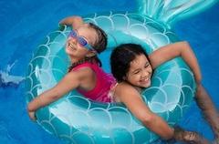 Kinder mit Schwimmring im Wasser