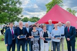 Gruppenfoto von 10 Personen, 8 von Ihnen mit Ehrenamtspreisen in der Hand
