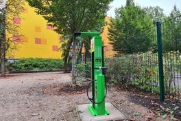 grüne Säule mit Werkzeug und Hängevorrichtung vor der gelben Wand der Schule am Krugpark