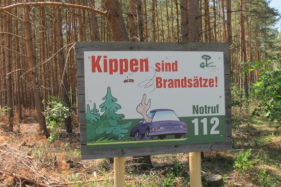 Eines der aufgestellten Schilder in einem Wald.