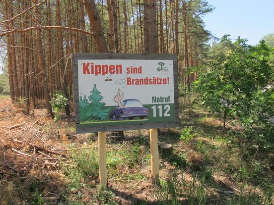 Eines der aufgestellten Schilder in einem Wald.
