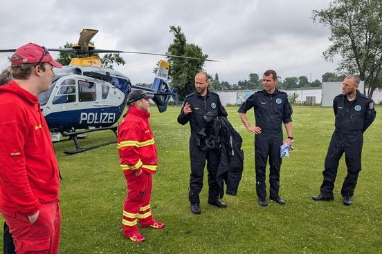 Lagebesprechung zwischen Polizei und DLRG-Kräften