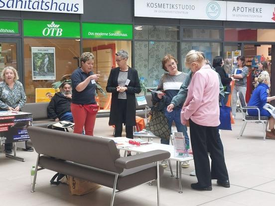 Menschen diskutieren stehend über Pflege