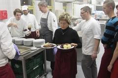 Dietlind Tiemann hilft beim Servieren des Hauptganges (Gänsekeule mit Klößen und Rotkohl)