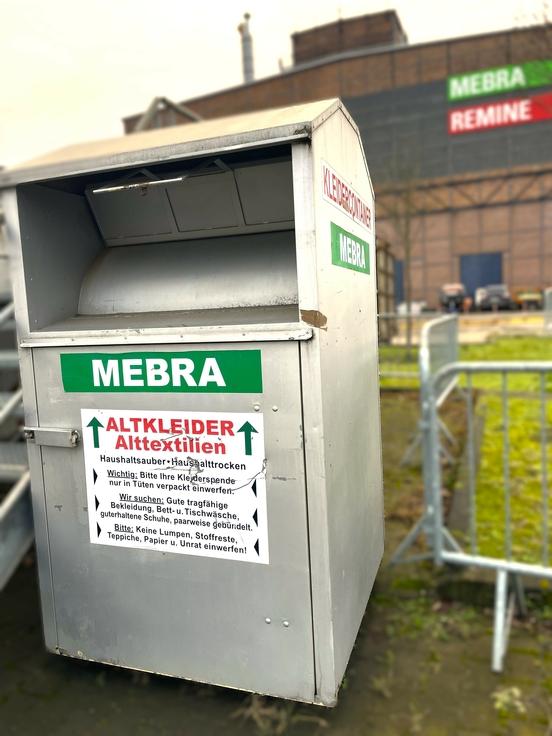 Ein silberner Altkleiderconatiner der MEBRA auf dem Wertstoffhof