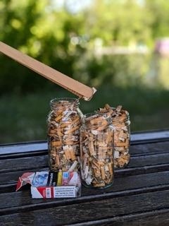 Zigarettenkippen in einem Glas.