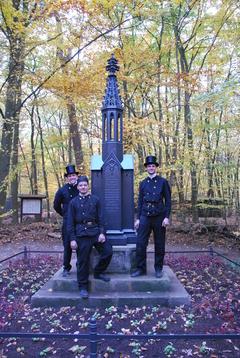 Schornsteinfeger stehen vor dem Denkmal