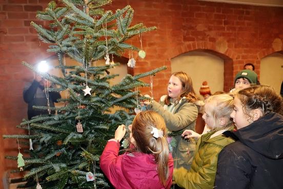 Die Kinder beim Schmücken des Weihnachtsbaumes