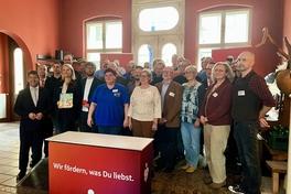 Eine Menschengruppe lächelt in die Kamera