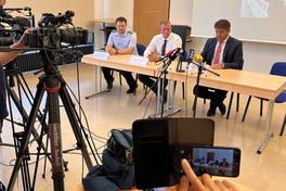 Kameras, die auf die drei Personen am Tisch gerichtet sind